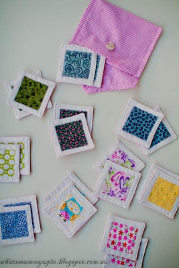 Quilting scraps matching game with quilted white fabric tiles appliqued in green blue and pink prints and a pink pouch