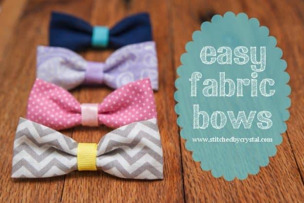Four fabric scrap bows in navy, lavender, pink dot and grey chevron on a wood table beside a typeset easy fabric bows label