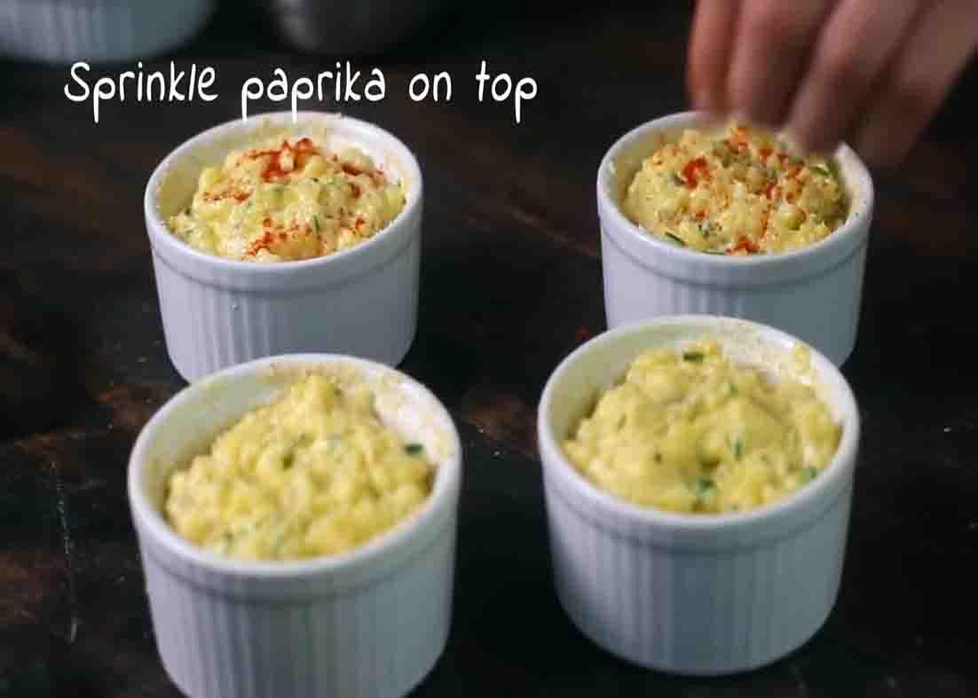 Sprinkling some paprika on top of potato souffle