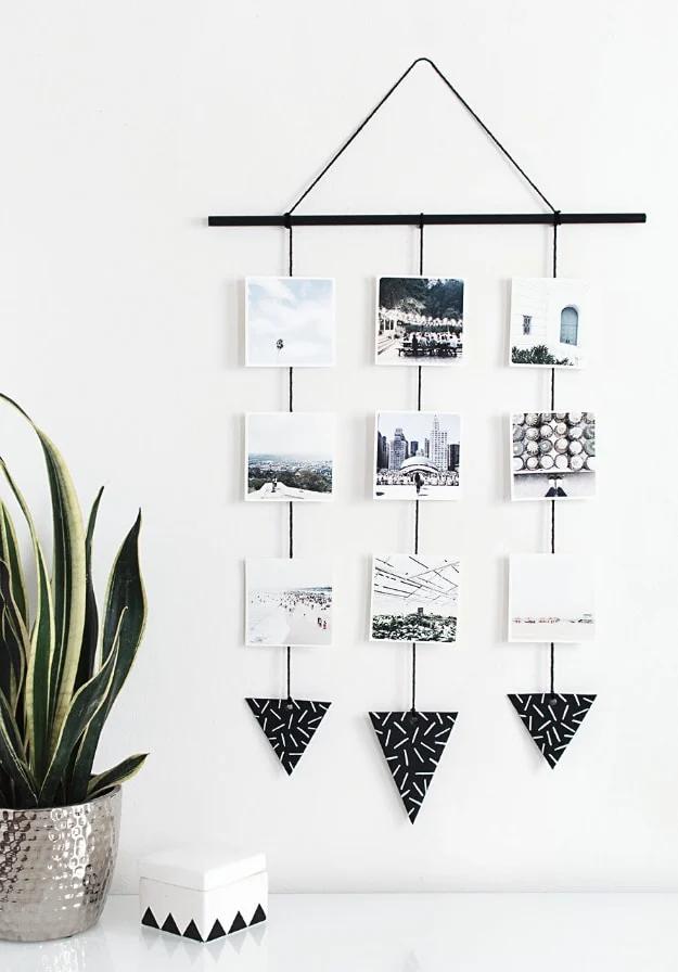 DIY photo wall hanging, a black dowel with three yarn lines of small photos and black clay triangles weighting the ends