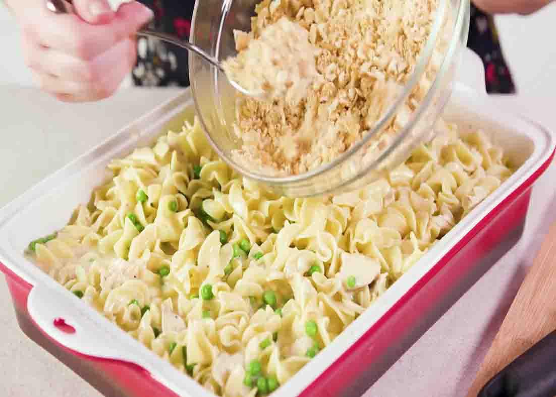 Sprinkling the parmesan Ritz over the creamy chicken casserole