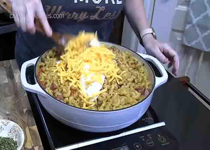 Adding sour cream and cheese to the sausage and pasta skillet