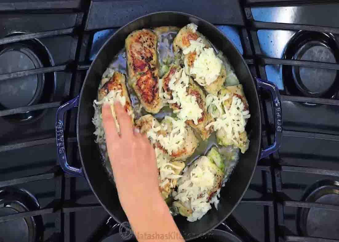 Sprinkling some mozzarella cheese over the chicken pesto roll-ups