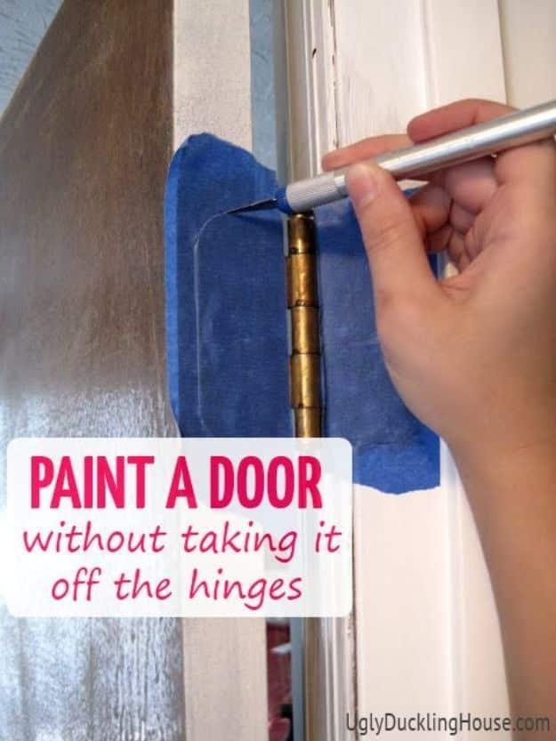 Painting hack for doors, a craft knife cutting blue tape along a brass hinge so the door can be painted in place