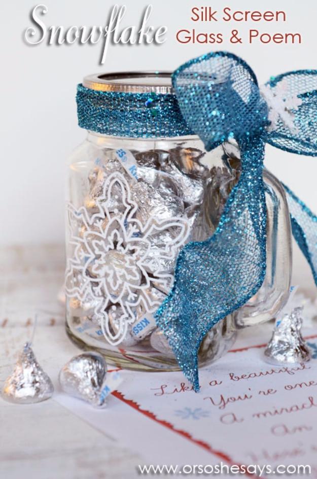 Glass mason jar mug silkscreened with a white snowflake, filled with foil wrapped candy and a teal ribbon