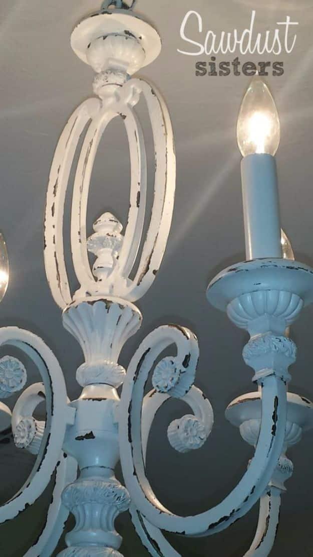 Thrift store chandelier makeover painted white with aqua arms and sanded distressing on the center column
