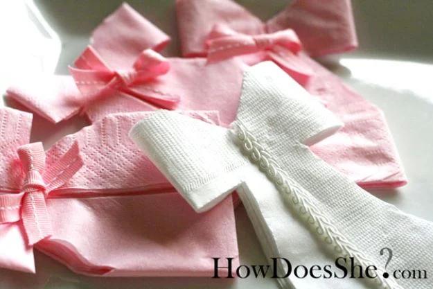 DIY baby shower decoration napkin dresses folded from pink and white paper napkins with ribbon and lace bows