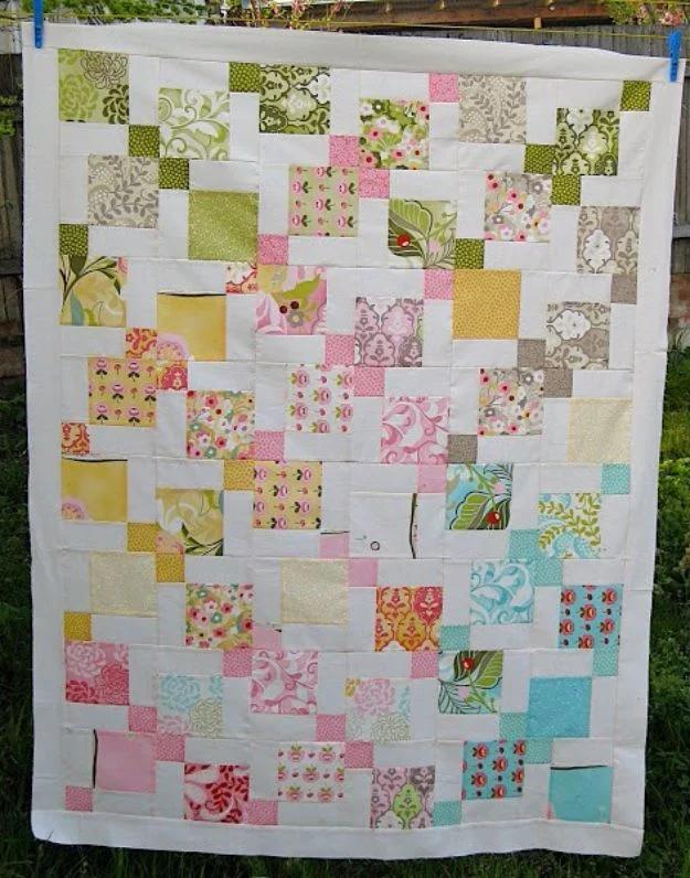 Moda Hunky Dory charm pack quilt top in pink, aqua and olive prints on white, hanging on a clothesline