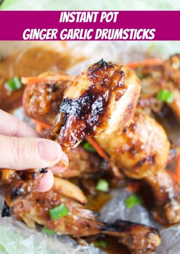 Graphic reading Instant Pot Ginger Garlic Drumsticks over a hand lifting a glossy browned chicken drumstick from a tray