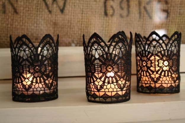 Black lace votives, three glass tealight holders wrapped in scalloped black lace trim glowing against a burlap backdrop