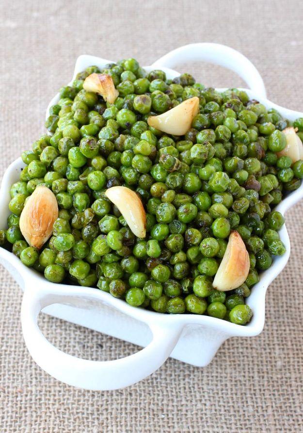 Brown butter and garlic roasted peas with whole roasted garlic cloves spread across a rimmed sheet pan