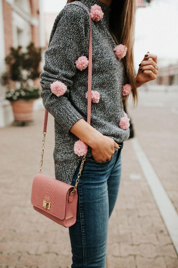 Gray marl sweater with soft pink yarn pom poms sewn across the shoulder and sleeve, worn with a pink bag