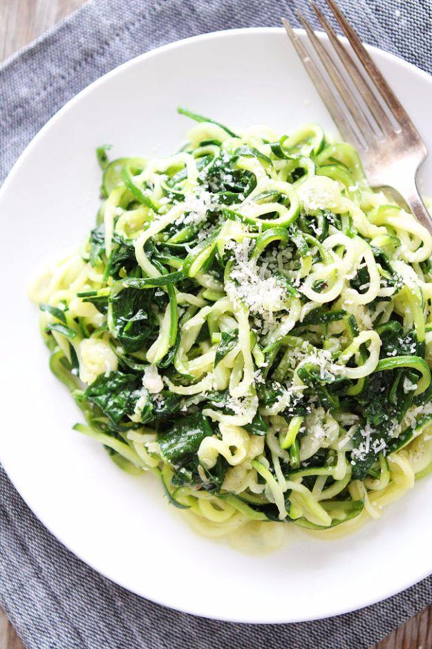Spinach parmesan zucchini noodles with wilted greens and grated parmesan on a white plate with a fork