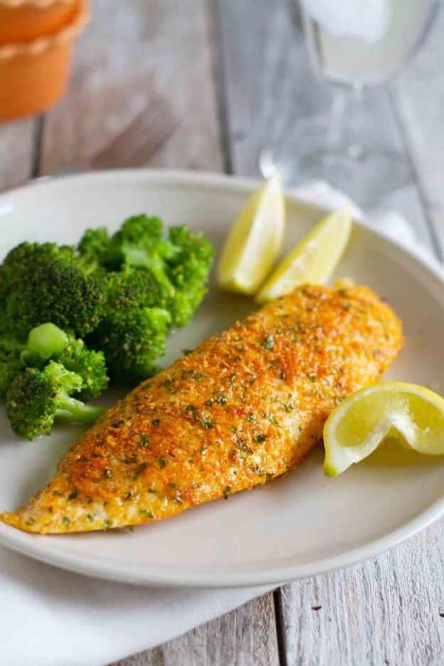 Parmesan crusted tilapia baked on a sheet pan with lemon wedges, a fast and easy baked tilapia recipe