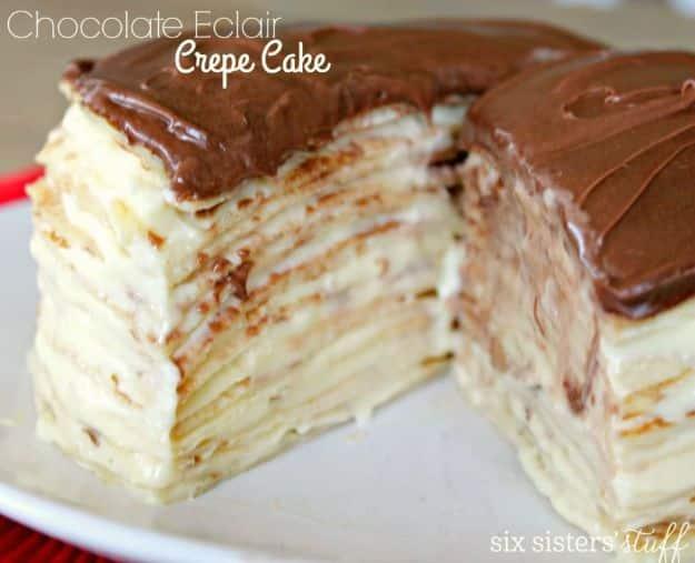 Chocolate eclair crepe cake cut open to show dozens of thin crepe layers under a smooth chocolate frosting