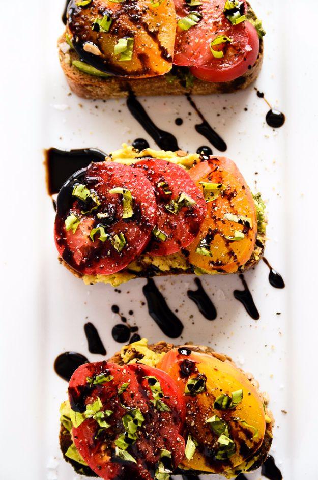 Avocado and heirloom tomato toast on hearty toasted bread with basil, sea salt and a balsamic drizzle