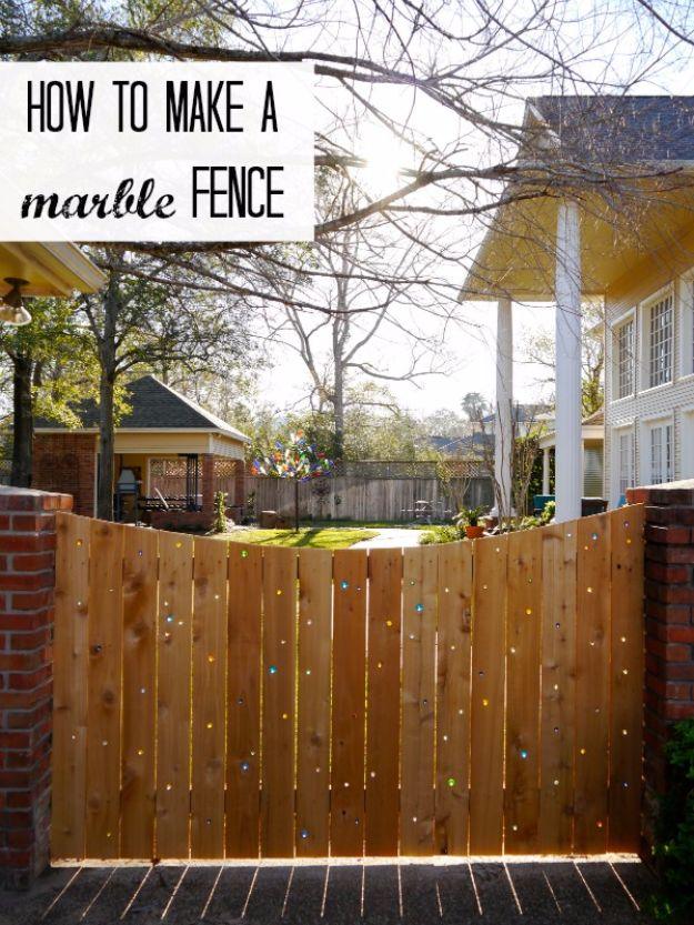 Marble fence, a cedar board fence with a curved top edge and colored glass marbles set into holes drilled through the boards