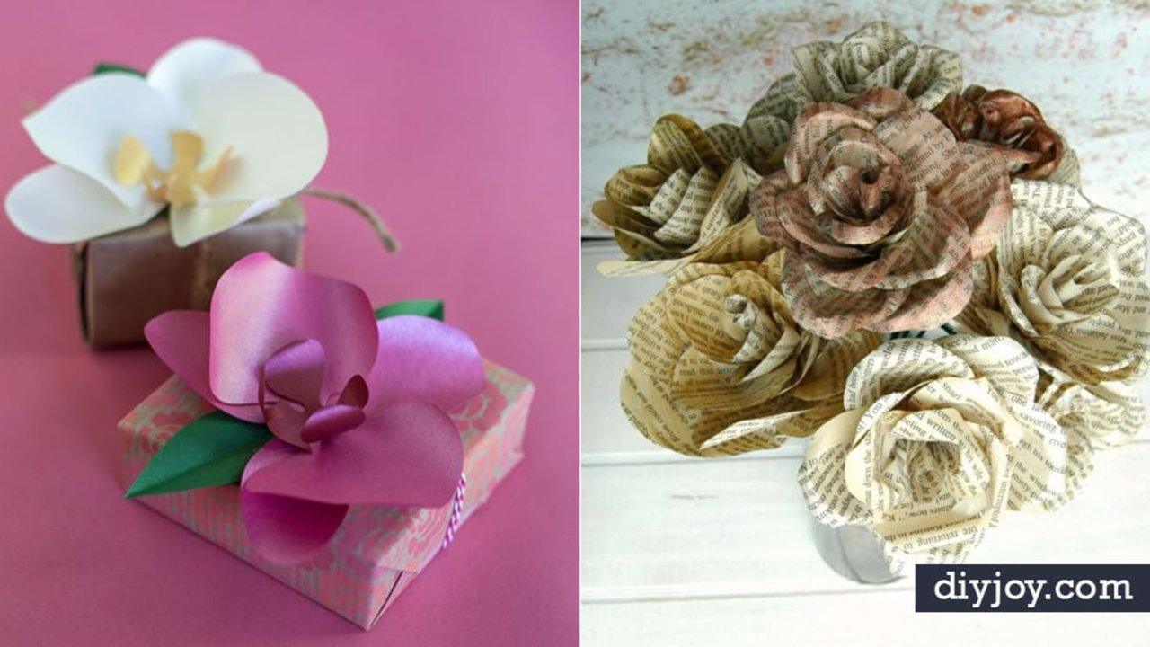 Paper flower ideas, white and pink paper orchids on wrapped gift boxes beside a pile of book page paper roses
