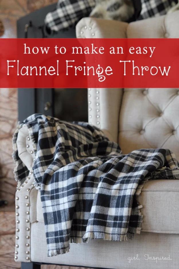 Black and white buffalo check flannel throw with a fringed edge draped over a pale tufted armchair arm