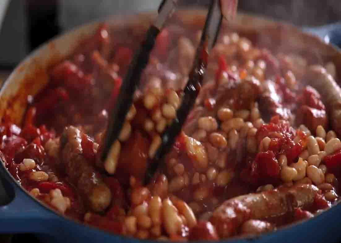 Cooking the added beans to finish the sausage and bean casserole