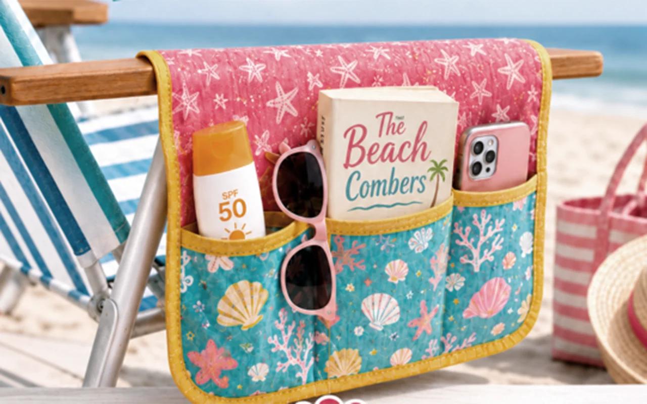 Hanging beach chair caddy in pink starfish and teal shell print canvas, pockets holding sunscreen, sunglasses and a book