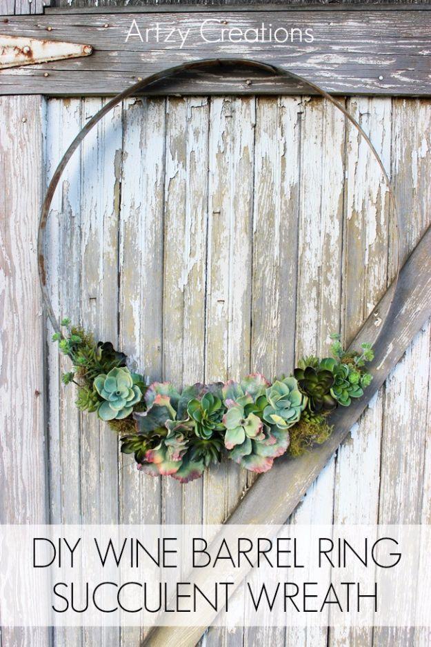 Wine barrel ring succulent wreath, a rusted metal hoop with faux succulents and moss hung on weathered barn wood