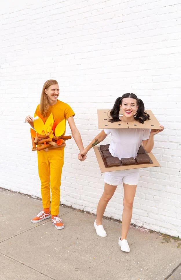 Campfire and s'more couples costume with painted foam log tubes, orange foam flames and cardboard graham crackers