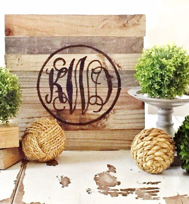 A large letter cut from reclaimed weathered boards hangs on a pale wall, the wood grain and nail holes still showing