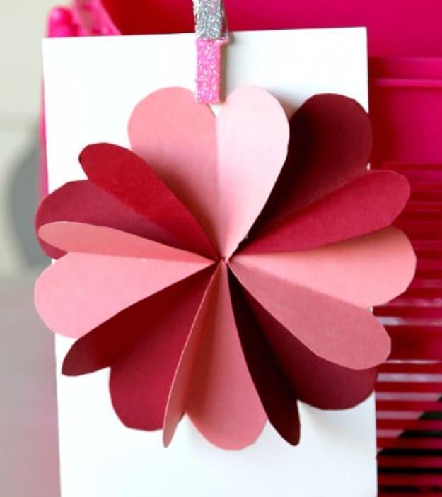 Hearts flower card with punched red and pink paper hearts arranged as flower petals on construction paper