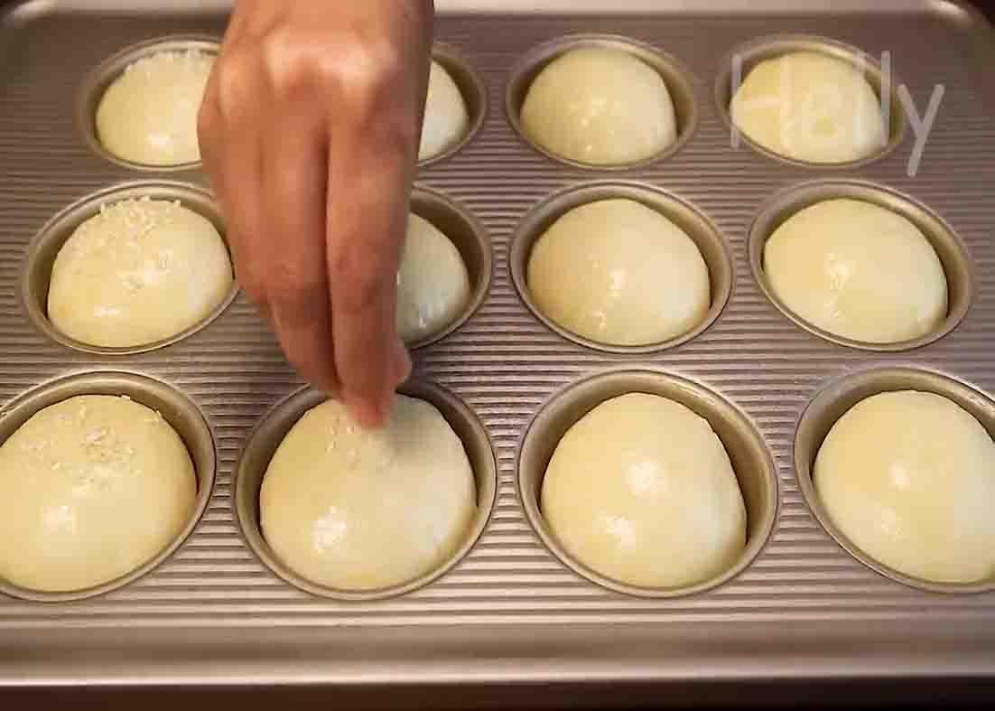 Sprinkling some sesame seeds on top of the potato buns