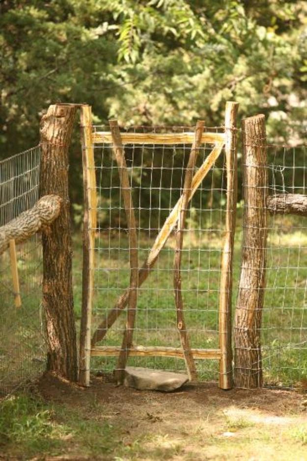 Beautiful rustic dog fence, rough log posts with wire mesh stretched between them and a matching rustic wooden gate