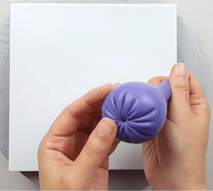 How to paint flowers with a balloon materials, a canvas, balloon, rubber band, marble, paint and a dotting tool