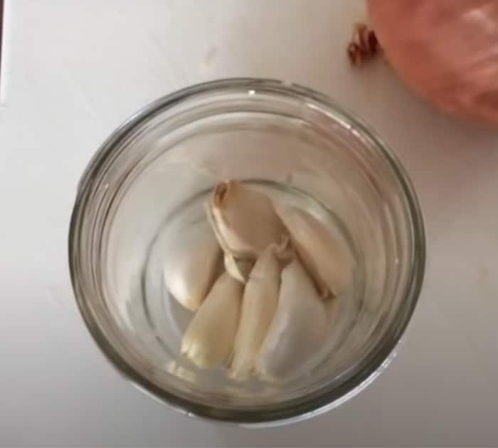 process of peeling garlic in a mason jar