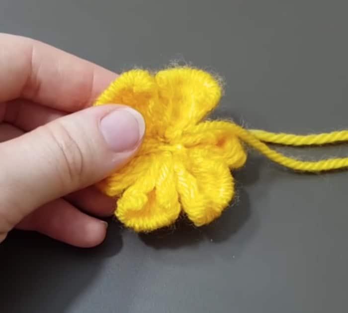 Make a yarn flower out of yarn and a fork