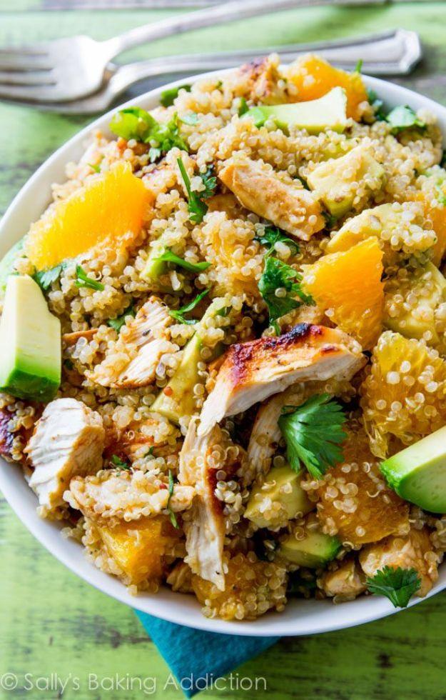 Citrus chicken quinoa salad in a white bowl with quinoa, sliced chicken, orange segments, avocado and cilantro