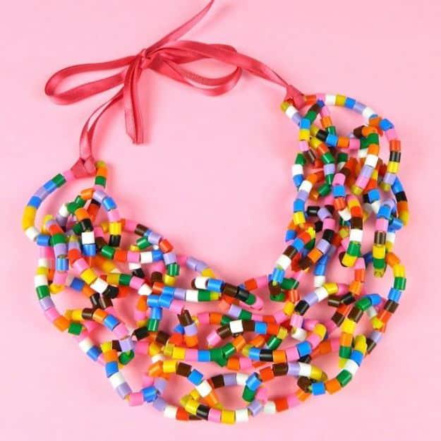 Beaded zip tie necklace, layered multicolored bead strands on zip ties finished with a pink ribbon tie on pink