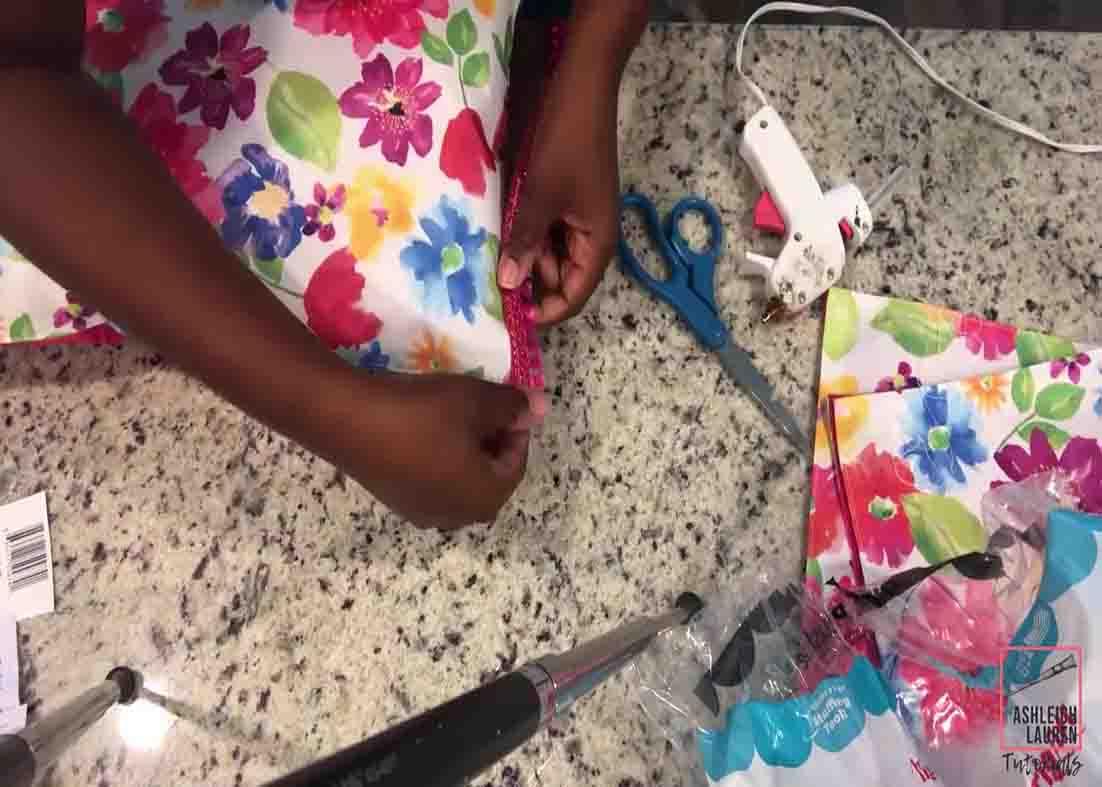 Gluing the trim to design the Dollar Tree floral pillows