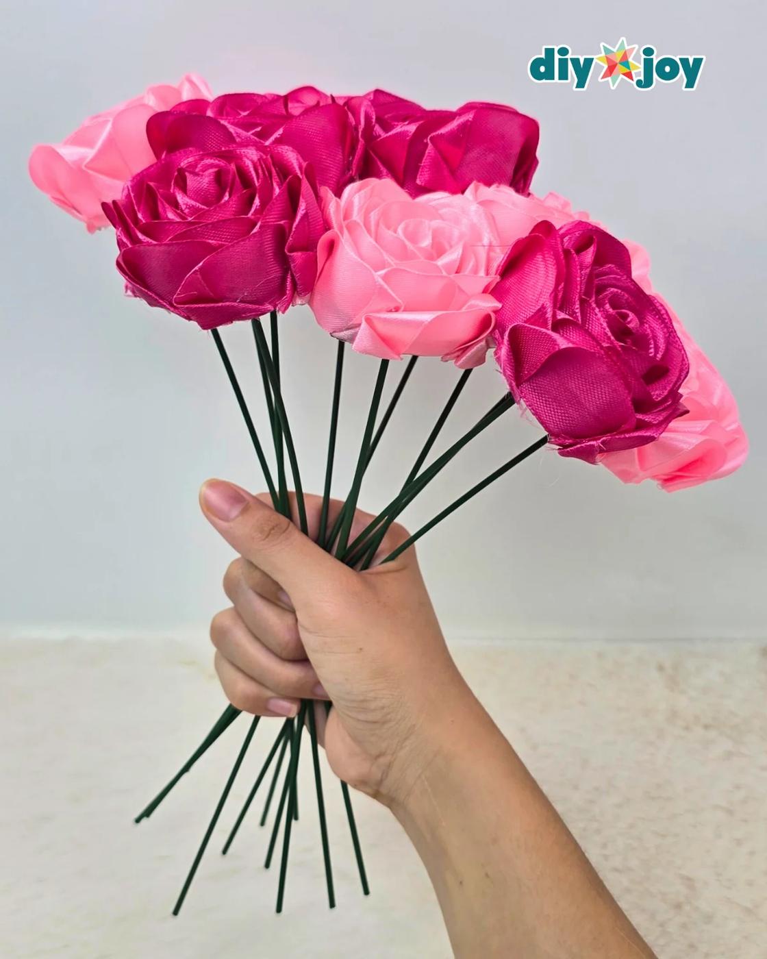 Ribbon rose made from satin ribbon, a realistic handmade flower with layered petals rolled onto a floral stem