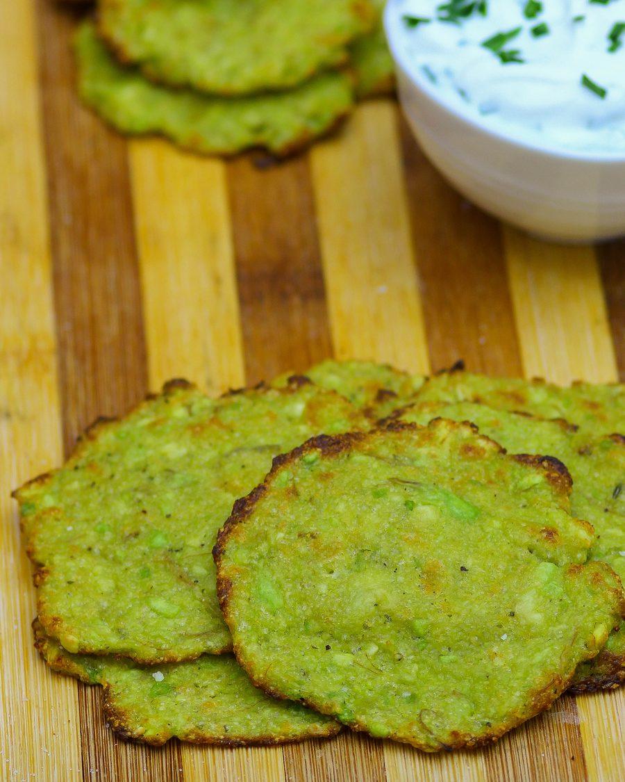 Low carb avocado chips snack with a bowl of herb dip on a wooden board