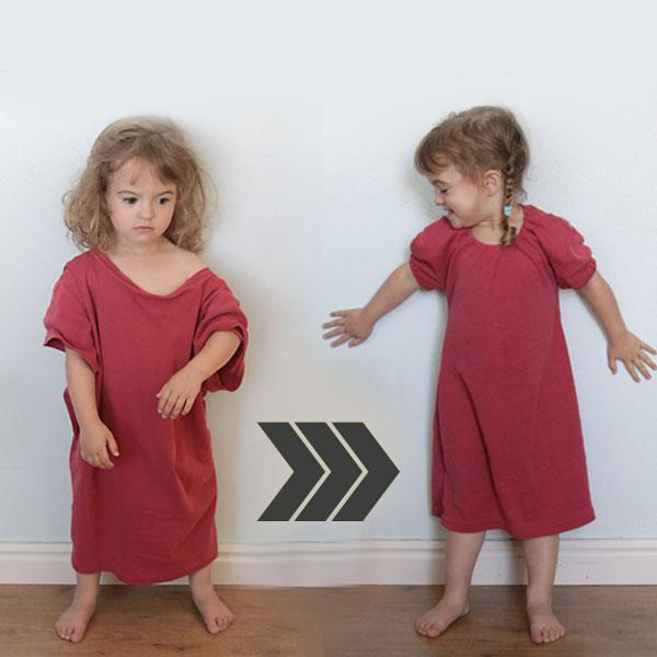 Two toddler girls wearing short dark red nightgowns made from t-shirts standing against a white wall