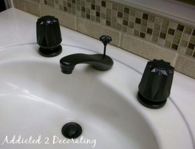 Bathroom sink with the faucet and both handles painted dark oil rubbed bronze against a green glass mosaic tile backsplash