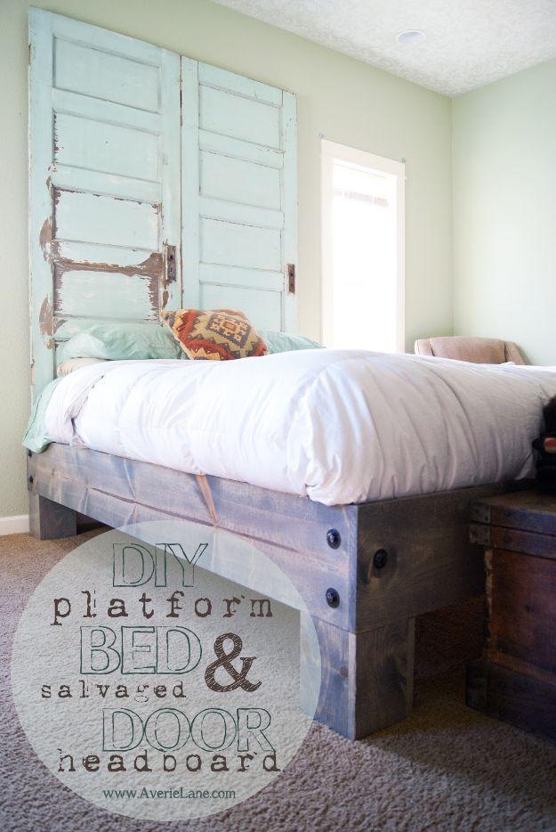 DIY platform bed graphic with two pale blue salvaged doors hung as a headboard above a grey plank bed