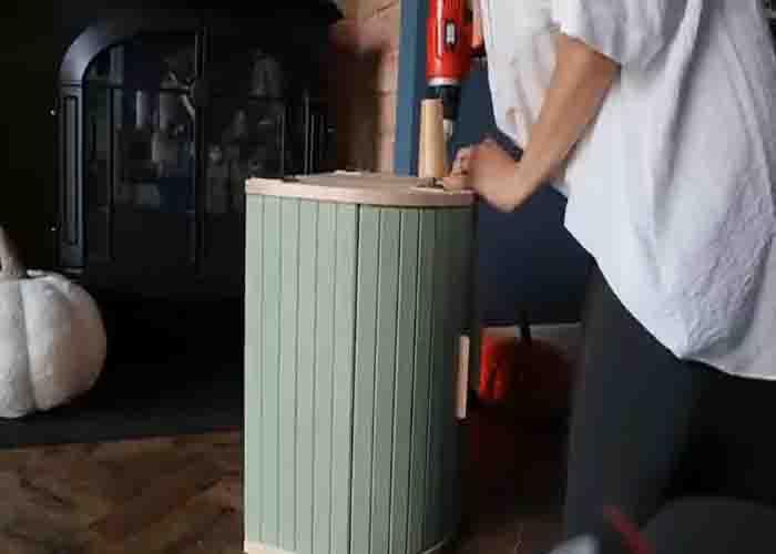 Attaching the legs of the DIY bedside table with IKEA bread bins