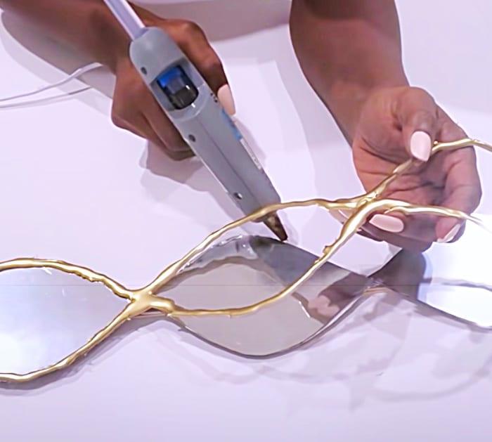 Use A Hot Glue Gun To Glue Silver Plastic Plates For A Wall Art Mirror