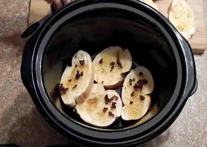 Layering the bread pudding on the slow cooker