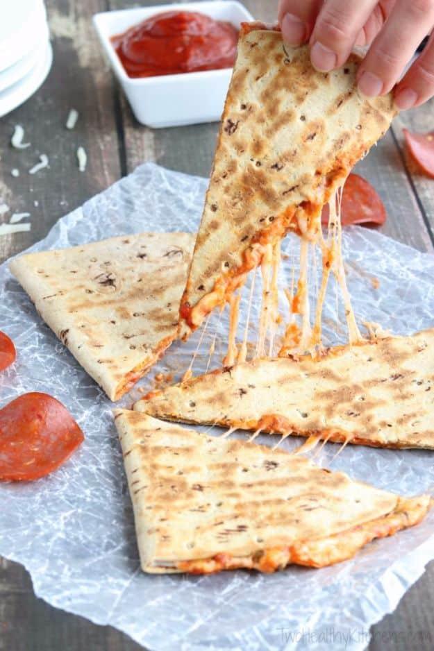 Crispy pepperoni pizza quesadilla cut into wedges with marinara for dipping, an easy five minute snack
