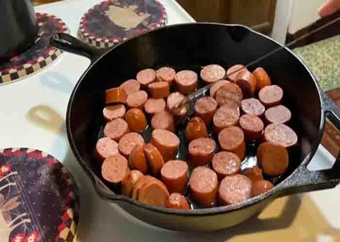 Frying the sausages for the baked beans and potatoes recipe