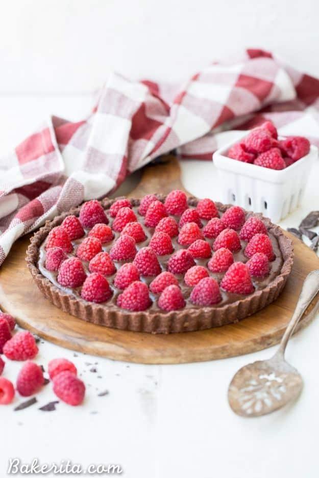 No bake raspberry chocolate tart with a dark chocolate ganache filling covered in fresh raspberries on top