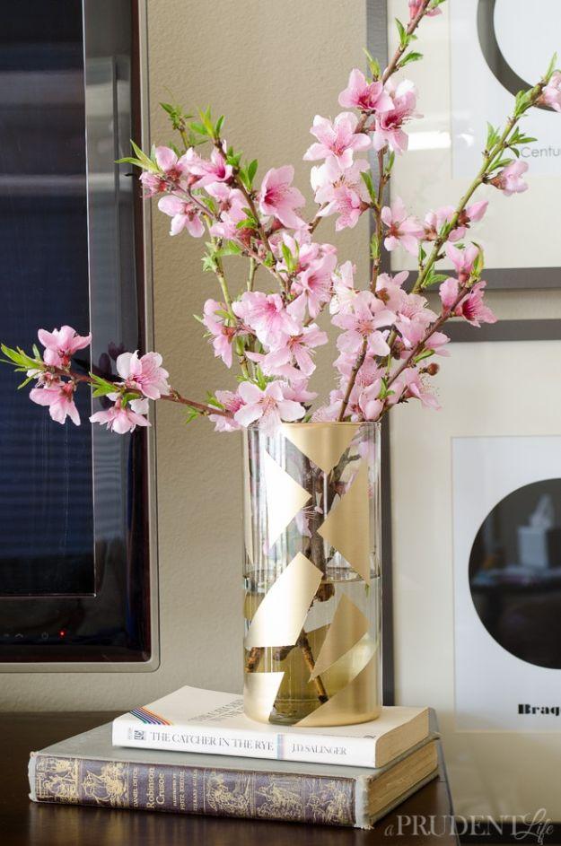 Cheap to chic vase makeover, a clear glass cylinder sprayed with a gold geometric pattern, holding blossom branches