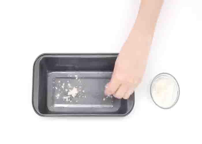 Greasing the loaf pan with butter and flour